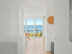 Un pasillo que conduce a un balcón con vista al mar.