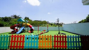 A playground with slides and swings, surrounded by a colorful fence. - 🌇 Fully Serviced 1-Bedroom Apartment at Riverbank, Two Rivers – Nairobi (Nairobi)