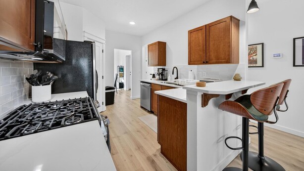 Una cocina moderna con una isla central, armarios de madera y una estufa a gas.