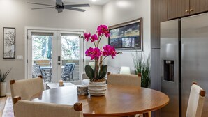 A modern kitchen with a round wooden table, chairs, a refrigerator, and a ceiling fan. - Bespoke Outpost: A stylish 3-bedroom retreat in scenic Chattanooga, TN. (Chattanooga)
