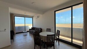 A spacious balcony with a view of the beach, a dining area with a table and chairs, and a sofa. - Joli Beach House - Third Floor T3 Apartment With Beautiful Views (Sal)