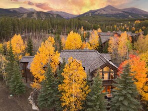 A lodge with multiple cabins surrounded by autumn foliage and mountains in the background. - True Ski-in Ski-out Estate, Luxury Suites, hot tub, gaming. AMAZING Home and Location! (Breckenridge)