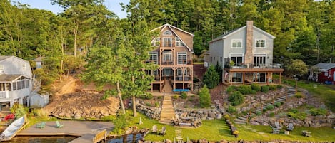 Une propriété au bord du lac, dotée d’un quai, d’un bateau et d’une maison avec une terrasse.