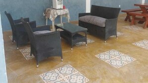 Une pièce avec un mur bleu, un distributeur d’eau, une table avec des chaises et un luminaire suspendu.