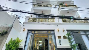 Un immeuble à plusieurs étages doté d’une entrée moderne, avec des portes en verre et un intérieur bien éclairé.