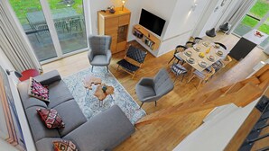 A modern living room with a sofa, chairs, a dining table, and a TV.