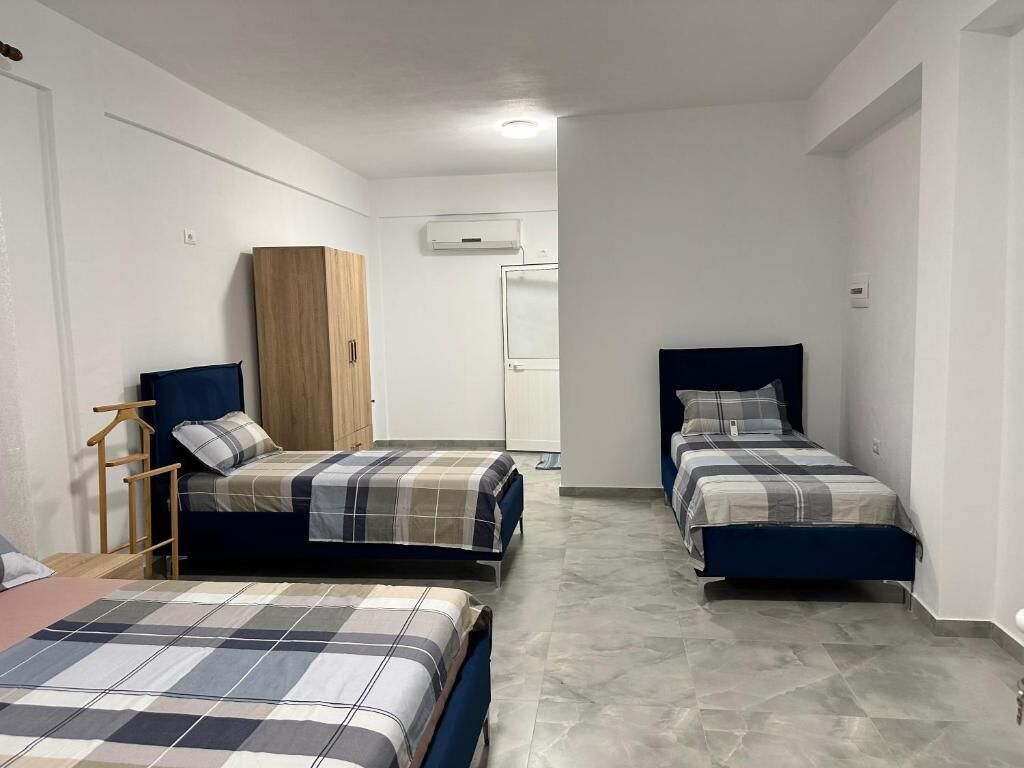 A room with two beds, a wardrobe, and a wardrobe mirror.