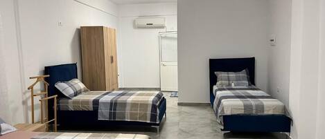 A room with two beds, a wardrobe, and a wardrobe mirror.