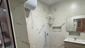 A bathroom with a shower, toilet, and sink.