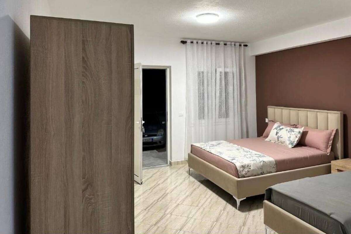 Un dormitorio con cama, armario y puerta que da a un estacionamiento.