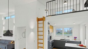 Um apartamento moderno com cozinha, sala de jantar e um quarto no mezanino.