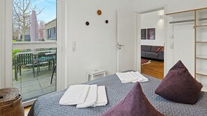 Quarto moderno com uma cama grande, vista para o exterior e uma sala de estar separada.