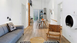 Un salon moderne avec un canapé, un coin repas comprenant une table et des chaises, et une cheminée.