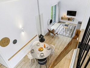 Un interior moderno con comedor, televisor y escalera.