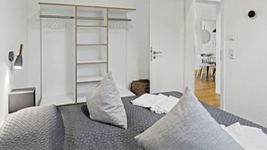 A bedroom with a bed, pillows, a wardrobe, and a bedside lamp. - Dümmerliebe 271 by Interhome (Lembruch)