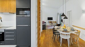A modern kitchen with a black refrigerator, wooden cabinets, and a dining area with a round table and chairs. - Dümmerliebe 271 by Interhome (Lembruch)