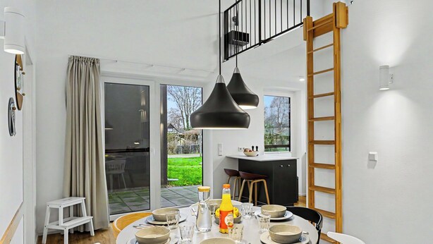 A dining area with a round table, chairs, and a black pendant light. - Dümmerliebe 271 by Interhome (Lembruch)