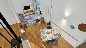A modern living space with a dining area, a sofa, a TV, and a view of the outdoors. - Dünenblick 165 (Seenähe) by Interhome (Lembruch)