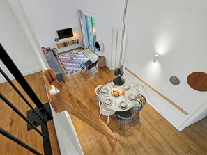 A modern living space with a dining area, a sofa, a TV, and a view of the outdoors. - Dünenblick 165 (Seenähe) by Interhome (Lembruch)