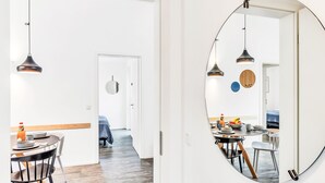 A modern interior with a dining area, a round mirror, and a hallway leading to a bedroom. - Zwischen den Hügeln 153 by Interhome (Lembruch)