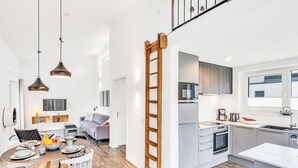 A modern kitchen with a central island, built-in appliances, and a window overlooking the city. - Zwischen den Hügeln 153 by Interhome (Lembruch)
