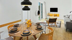 A modern dining area with a round table, chairs, and a black pendant light. - Küstenzauber 282 by Interhome (Lembruch)