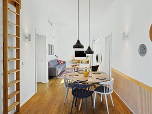 Ein modernes Interieur mit Essbereich, einer Couch und einer Holzleiter.