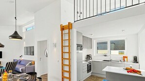A modern apartment with a dining area, kitchen, and a loft bedroom with a balcony. - Goldfisch 191 (Seenähe) by Interhome (Lembruch)