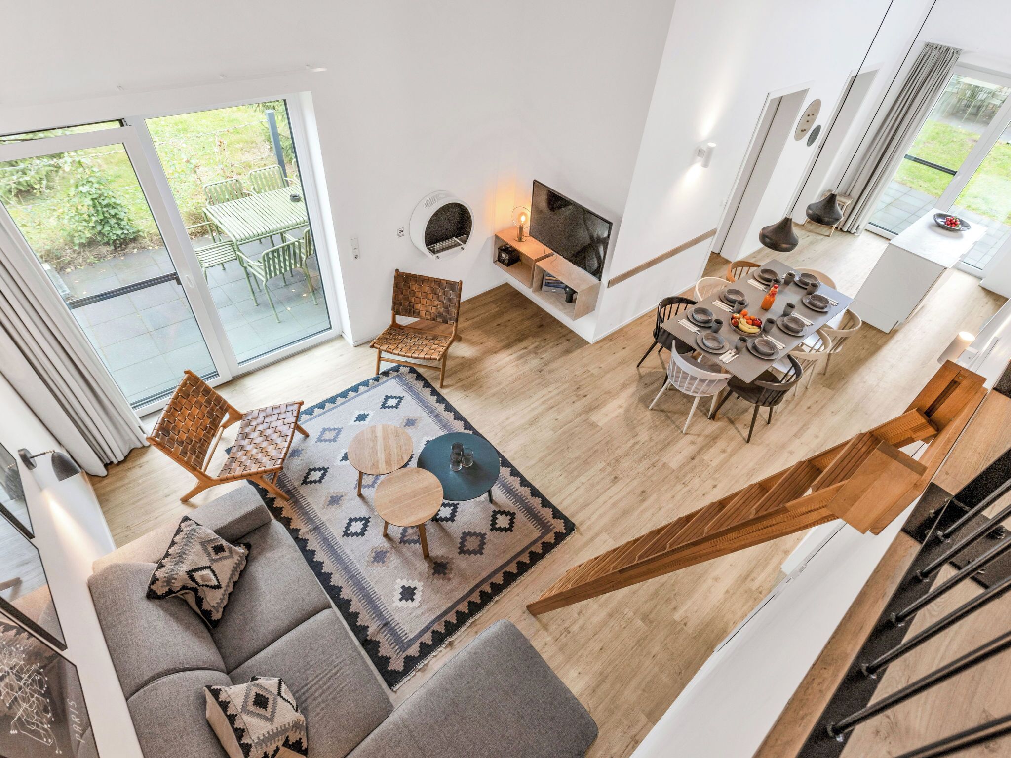 Un vaste espace de vie comprenant un canapé, une table basse et une table à manger pour quatre personnes.