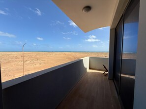 A balcony with a view of a desert landscape and the ocean. - Joli Beach House - Superb Santa Maria Apartment With Breathtaking Views (Sal)