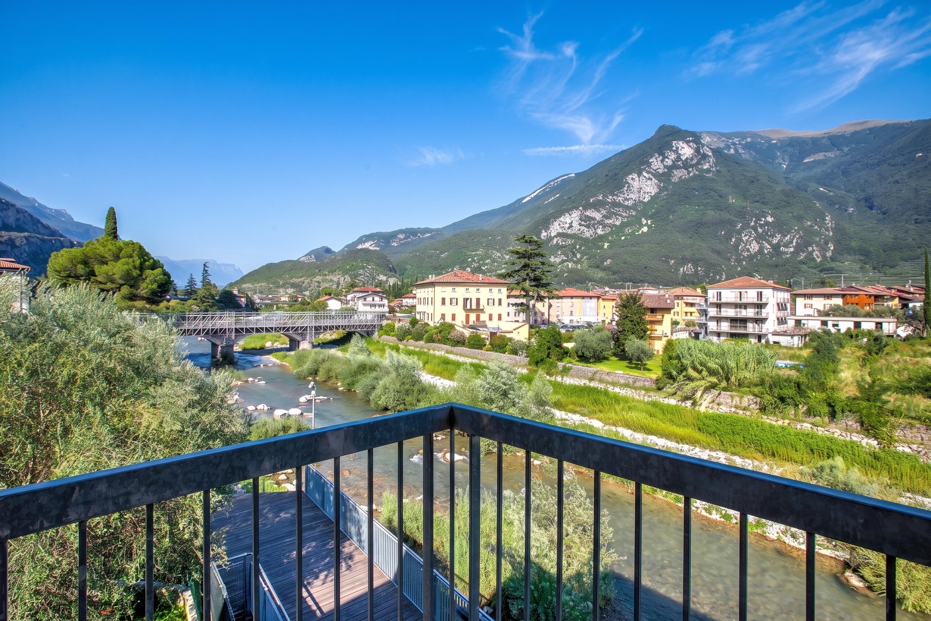 A river flowing through a town with buildings and mountains in the background.