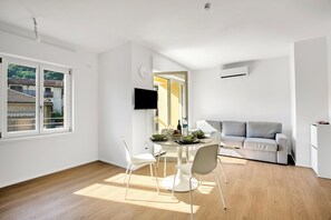 Un espacio de estar moderno con comedor, sofá y televisor.