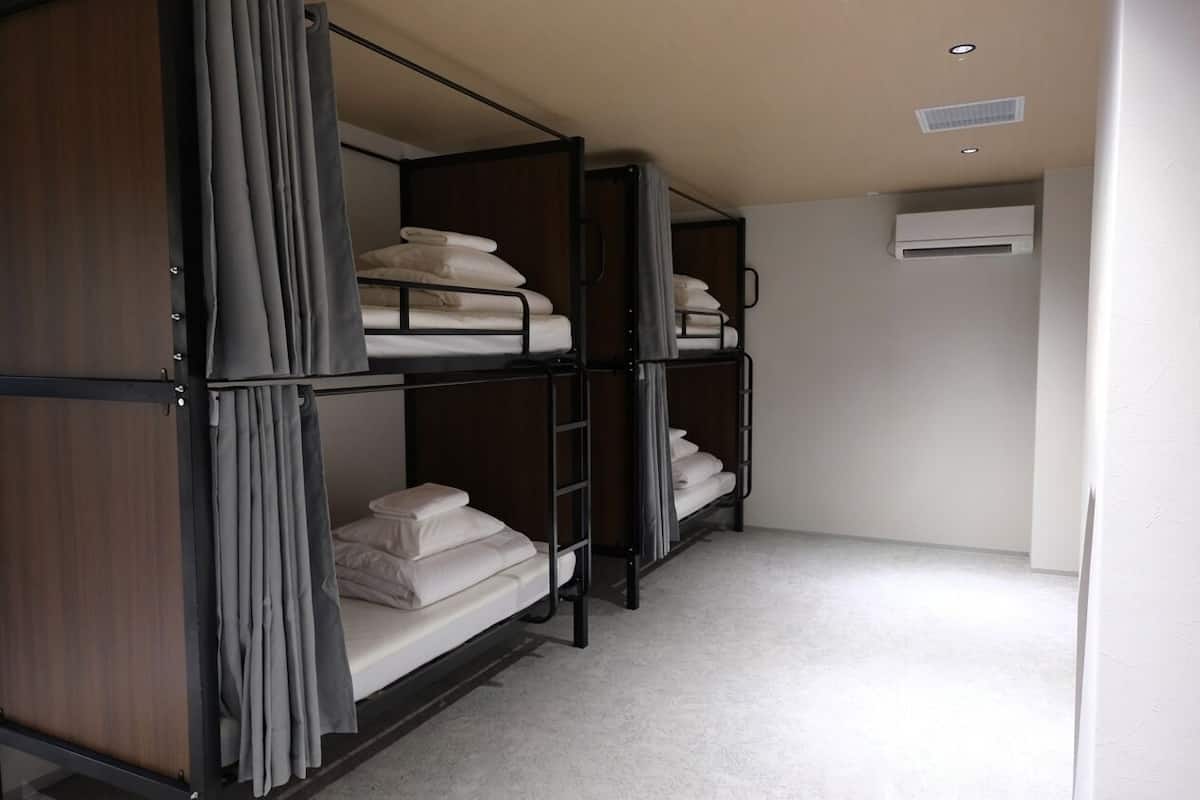 Une chambre avec des lits superposés, une armoire et un appareil de climatisation.