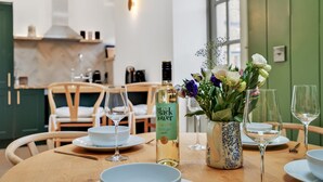 Ein Esstisch gedeckt mit Tellern, Gläsern und einer Flasche Black Tower Wein.