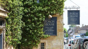 Zwei Schilder für 'The Porch House', die es als Pub mit Speiseraum und luxuriösen Zimmern in Brakspear ausweisen.