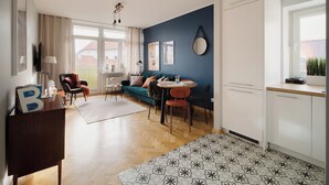 Een moderne woonkamer met een blauwe accentmuur, een eethoek met een ronde tafel, en een keuken met witte kasten.