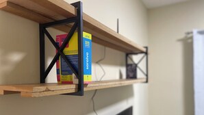 A shelf with a book titled 'Vade Mecum saraya' and a TV below it. - Ceo Studio Premium 4 | Comfort and Style close to everything (Aracaju)