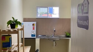 A compact kitchenette with a refrigerator, sink, and window. - Ceo Studio Premium 4 | Comfort and Style close to everything (Aracaju)
