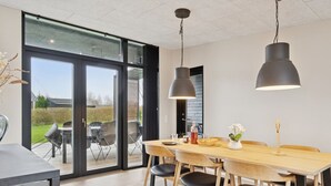 A modern dining area with a large table, chairs, and pendant lighting. - "Emelina" - 300m from the sea by Interhome (Odder)