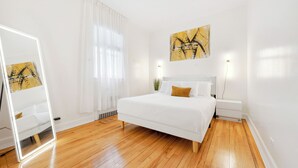 A bedroom with a bed, bedside tables, a mirror, and a painting on the wall. - Spacious 3BR Luxe Escape near NYC (Yonkers)
