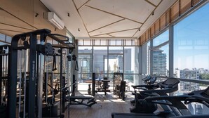 A gym with cardio equipment, weight machines, and a view of the city. - Terrae Pinheiros (São Paulo)