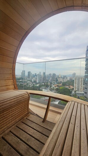 A circular wooden balcony with a view of a cityscape. - Terrae Pinheiros (São Paulo)