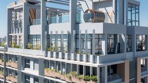 A modern multi-story building with balconies, large windows, and a cylindrical structure on the roof. - Terrae Pinheiros (São Paulo)