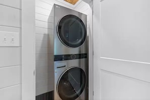A wall-mounted washer and dryer unit with a control panel and a wooden ceiling above. - Gracewood Creek - Luxury Cabin, New Heated Pool (Broken Bow)