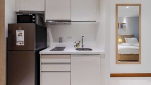 A compact kitchenette with a refrigerator, microwave, and sink. - Ocean Breeze1BR Steps from the Sea C244 (Rawai)