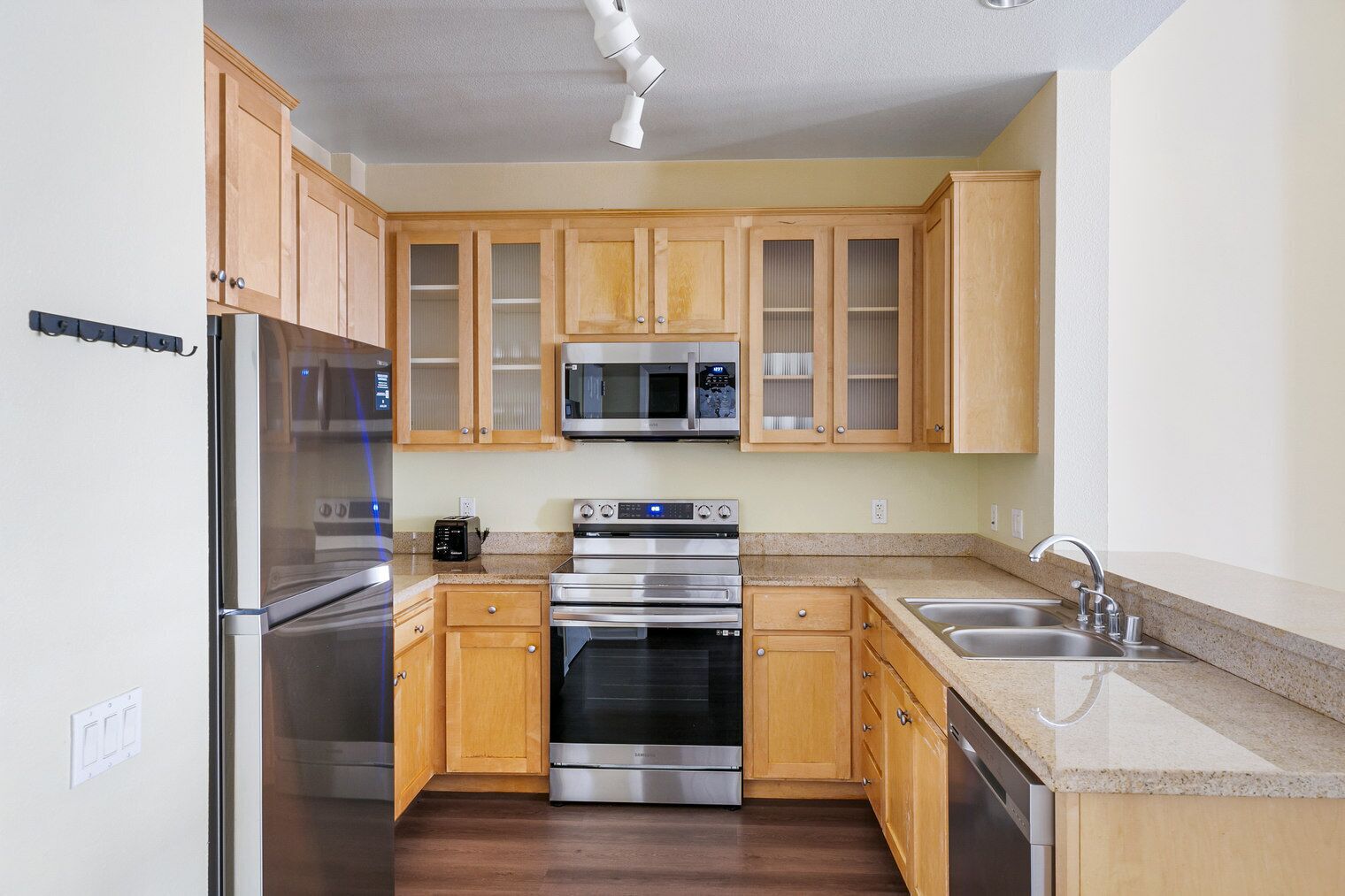 Een koelkast, een vaatwasser, kookgerei, borden en bestek