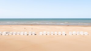 Een strand met rijen witte strandhutten.