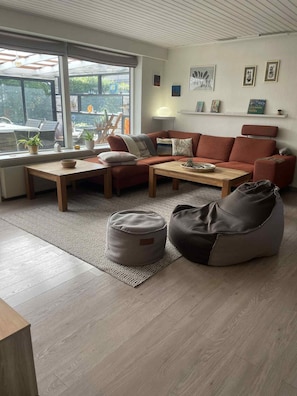 Un salon moderne avec un canapé, une table basse, un fauteuil poire et un tapis à motifs.