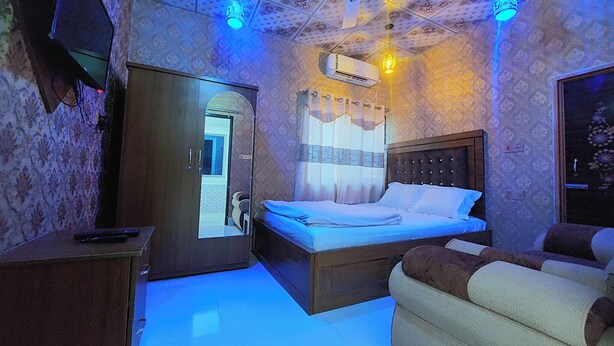 Un dormitorio con cama, armario, sofá y aire acondicionado.