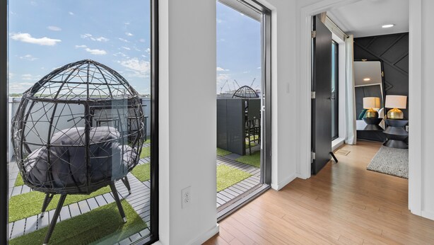 A modern interior with a large glass door leading to an outdoor area featuring a spherical hanging chair. - NEW! 1mi->Broadway! Top of the Tune Penthouse (Nashville)